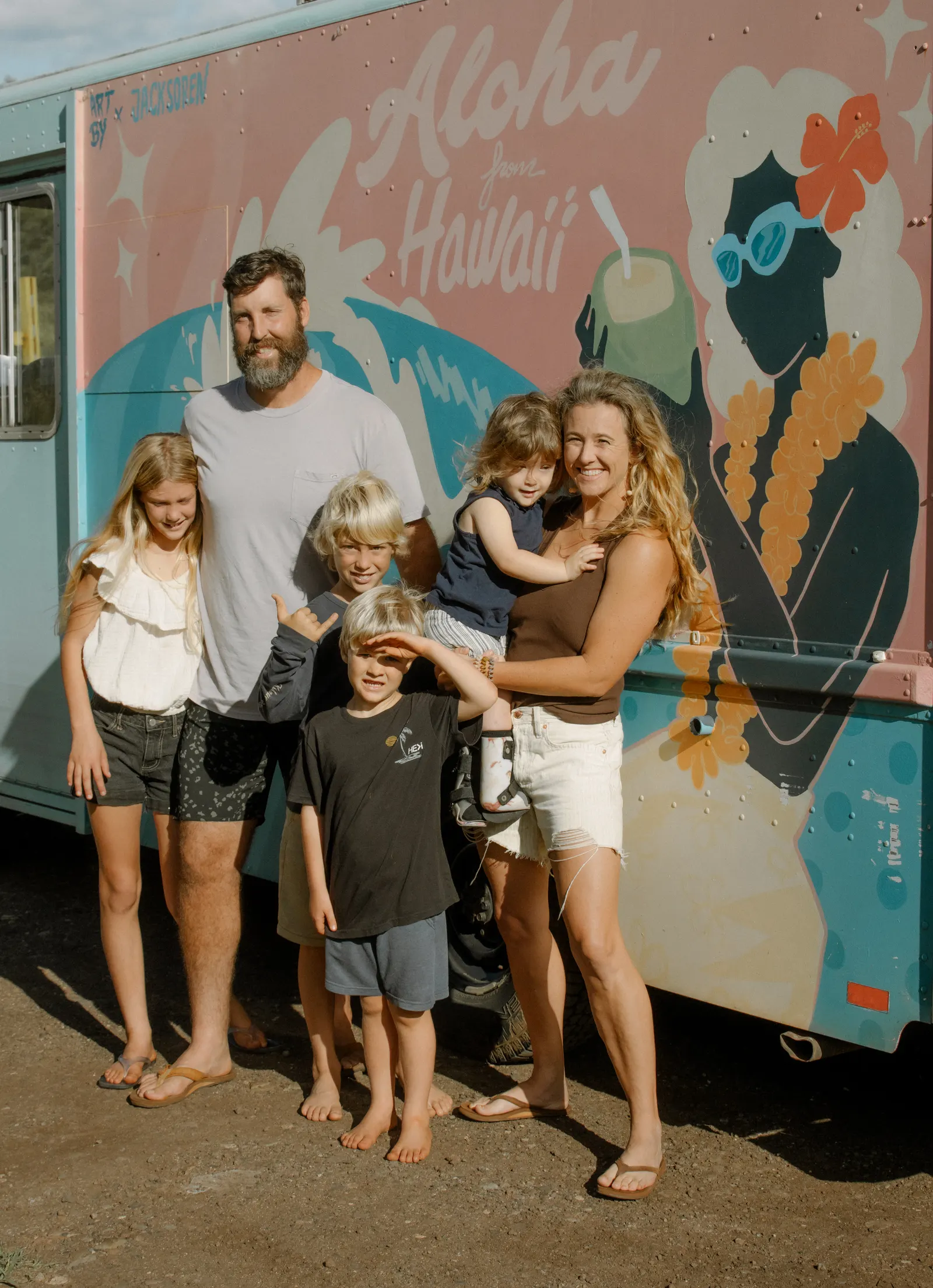 The Smee ohana standing in front of the Aloha from Hawaii mural