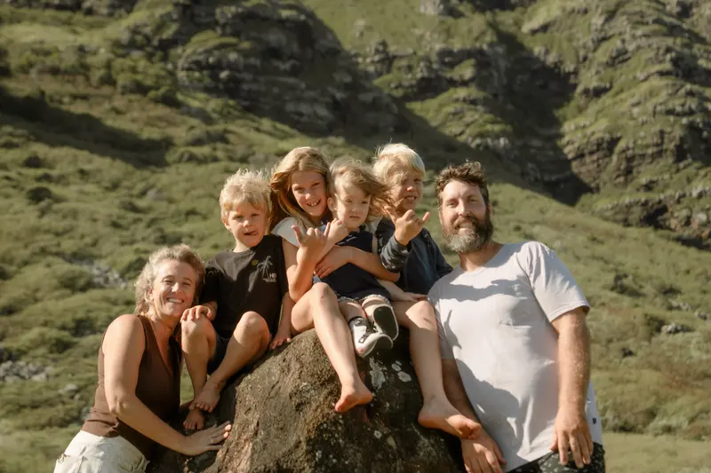 The Smee ohana sitting together on a boulder below the mountains