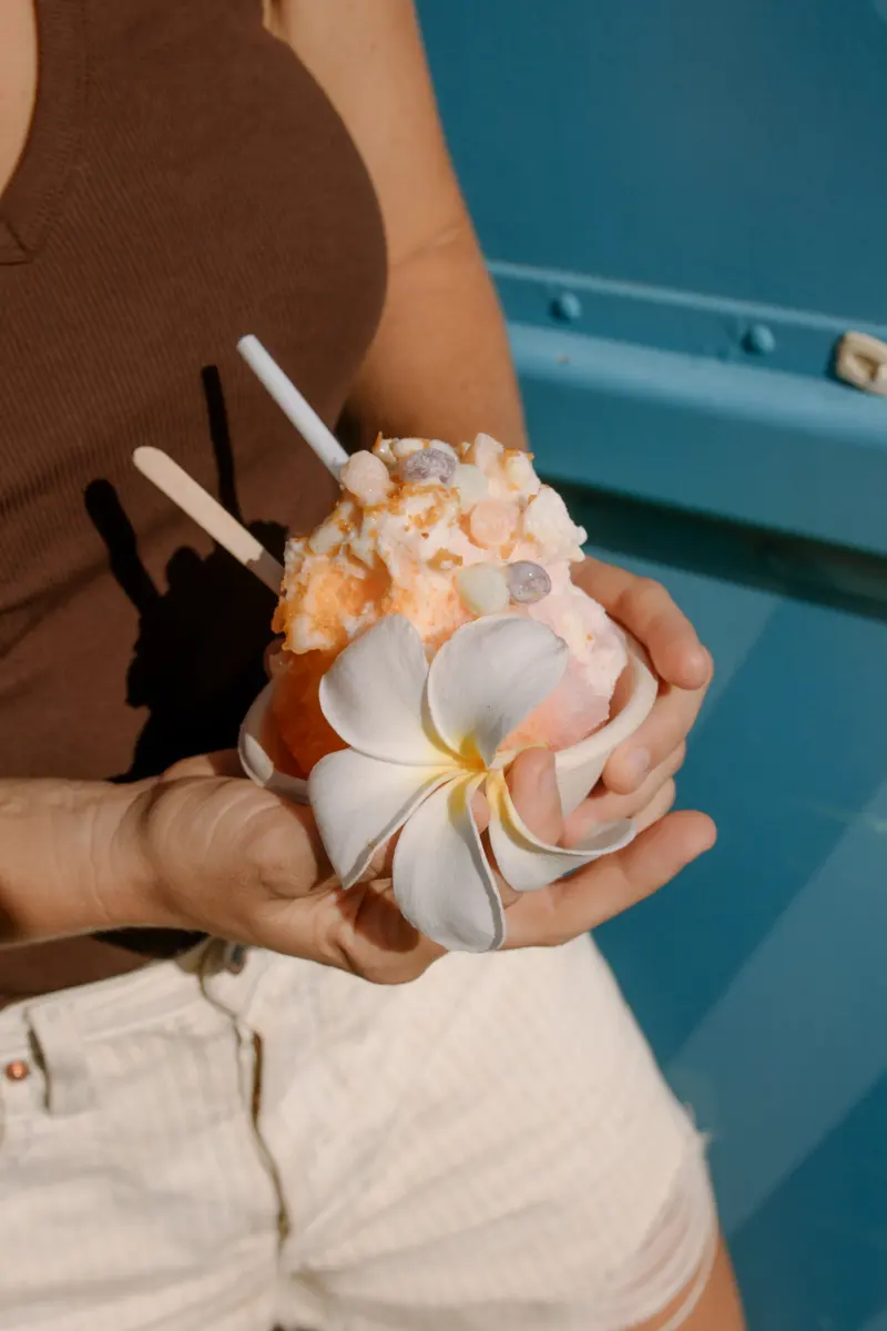 Shave ice topped with a plumeria flower