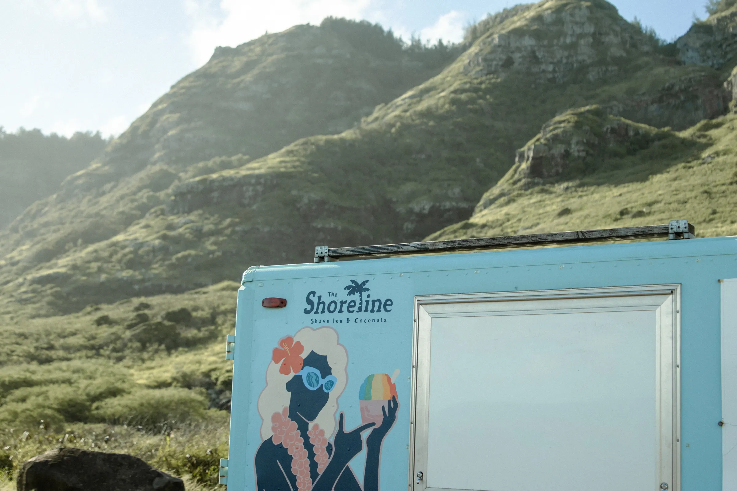 The Shoreline Truck parked below the green mountains of Oʻahu’s North Shore