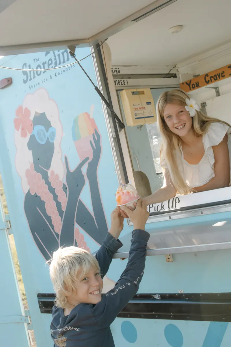 A young customer reaching up to the order window