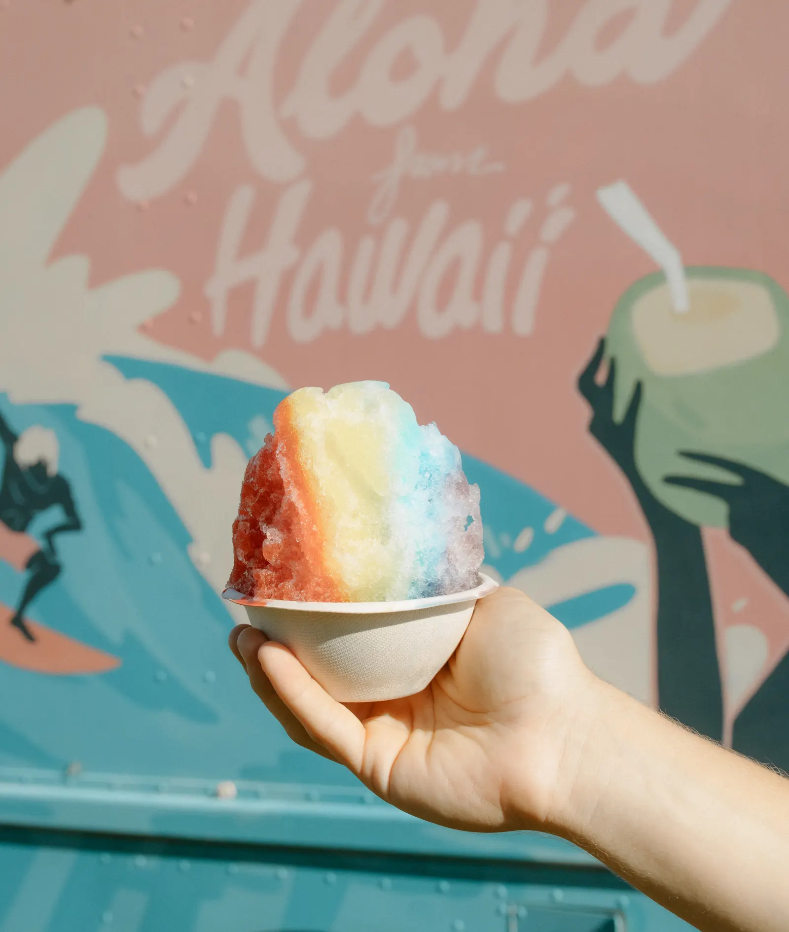 Rainbow shave ice in front of the Aloha from Hawaii mural